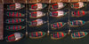 Four row of three red, white and green boats docked side by side on a body of water.