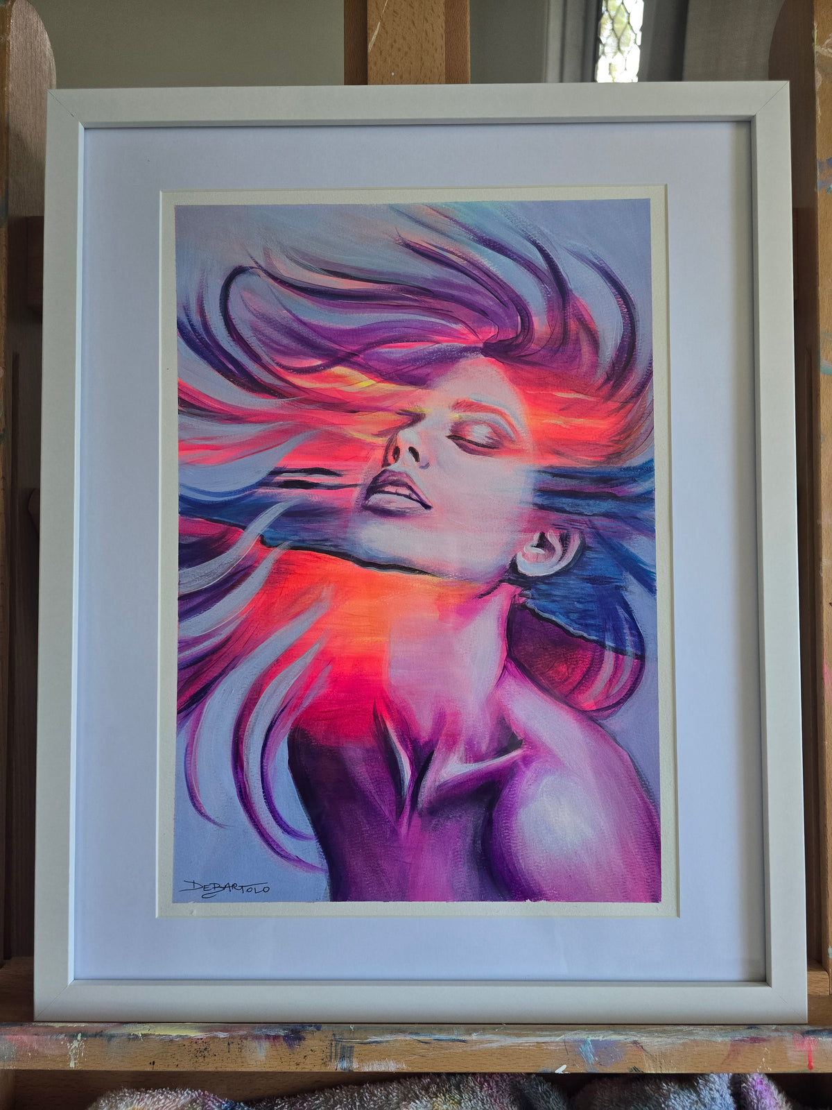 Breaking The Surface by Bianca Debartolo — acrylic and charcoal portrait in pink, purple and blue, presented in a white frame.
